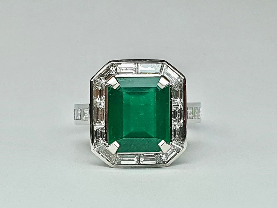 A stunning Platinum Cocktail ring set with an Emerald Cut Central Emerald and Diamonds