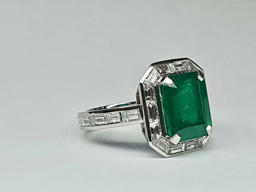 A stunning Platinum Cocktail ring set with an Emerald Cut Central Emerald and Diamonds