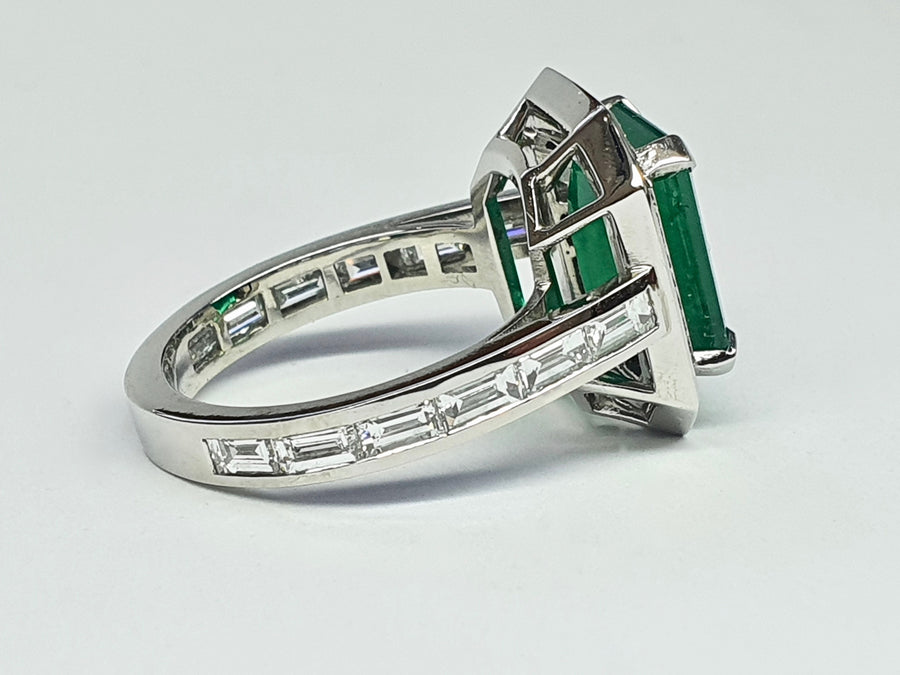 A stunning Platinum Cocktail ring set with an Emerald Cut Central Emerald and Diamonds