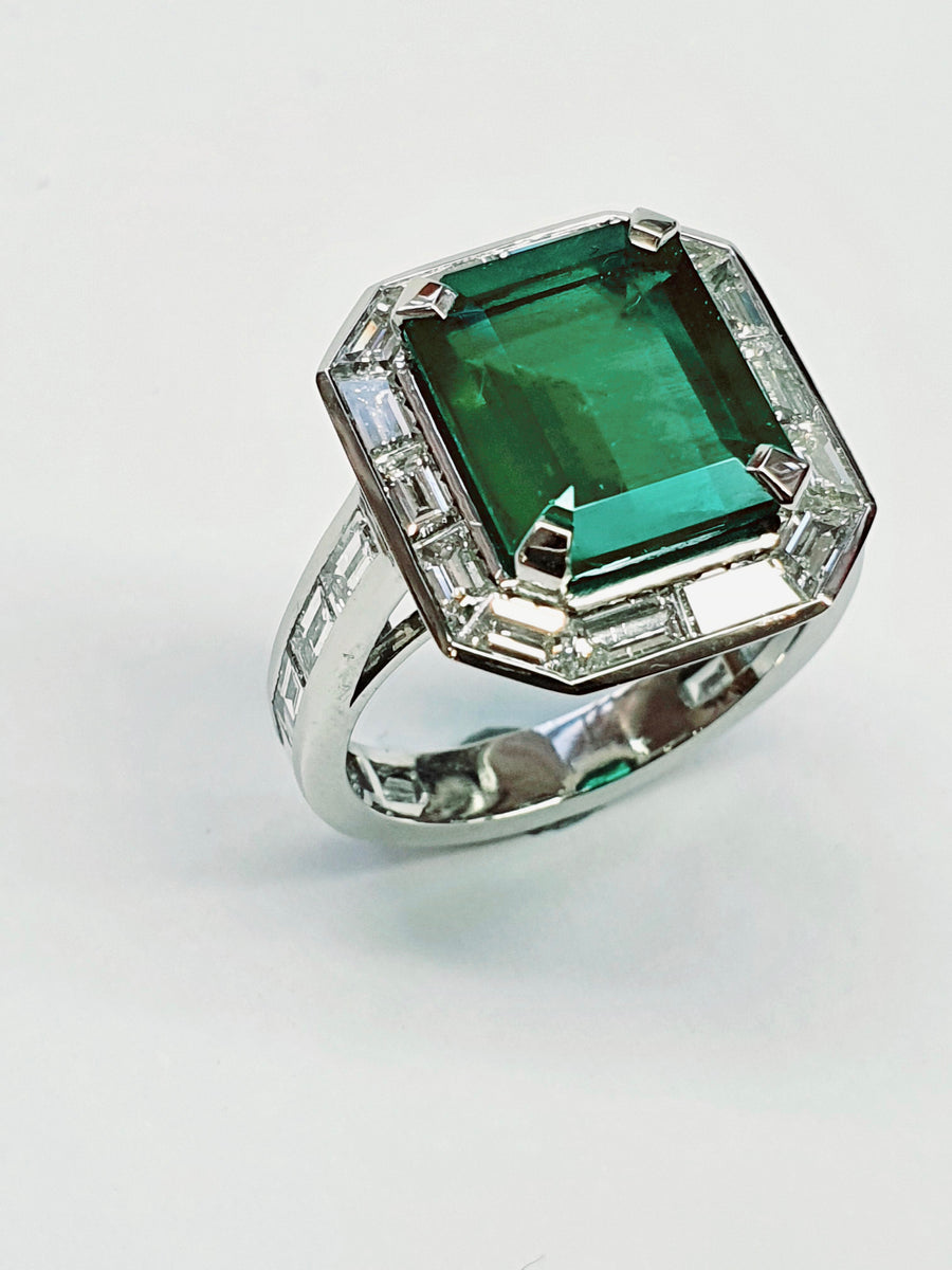 A stunning Platinum Cocktail ring set with an Emerald Cut Central Emerald and Diamonds